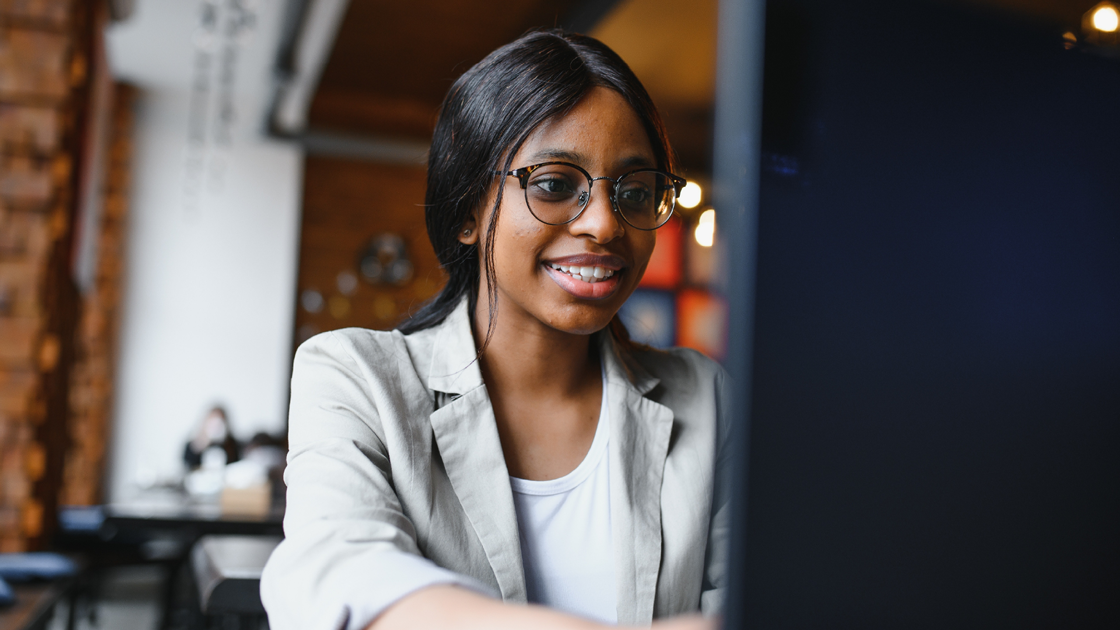 decorative image of a woman sitting behind a computer screen