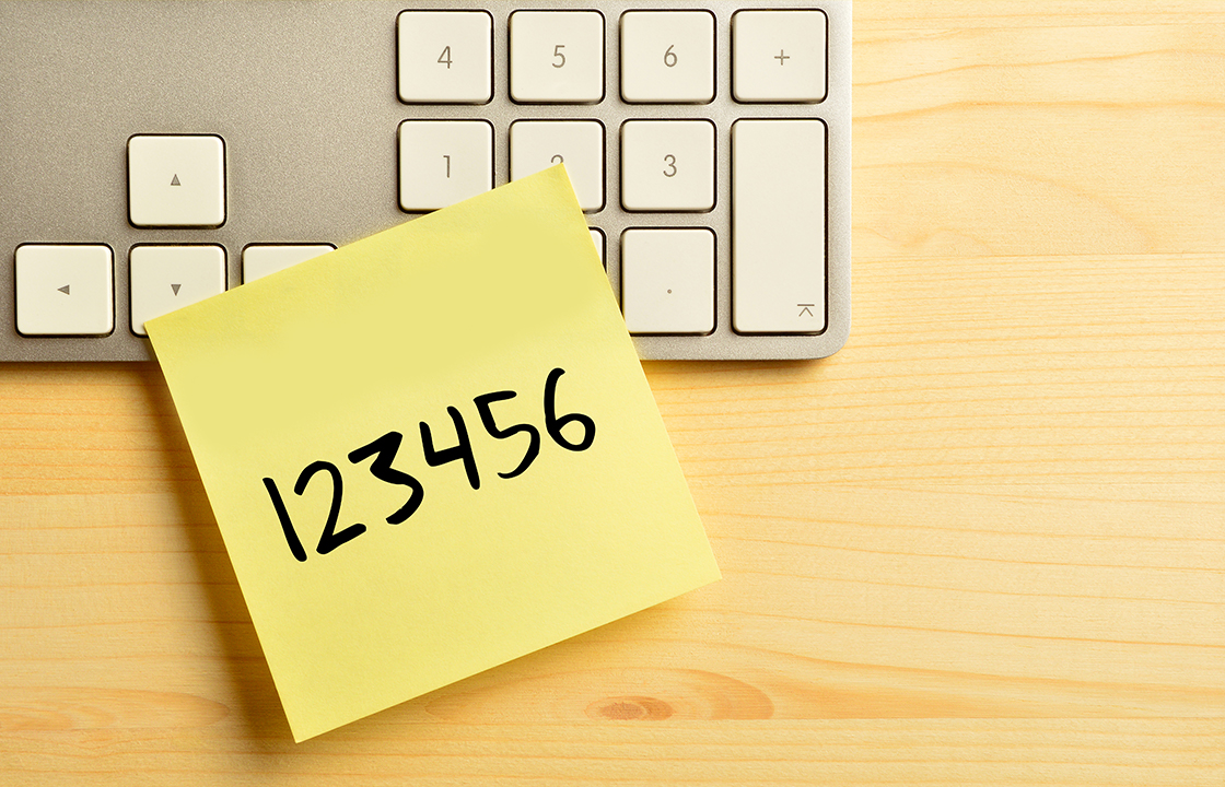 a yellow sticky note sitting on top of a keyboard with the numbers 123456 written on the sticky note